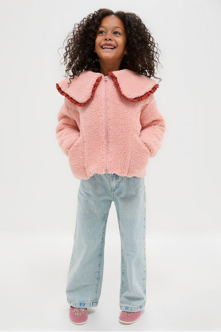 Young girl smiling in classic, effortless Pink Velvet Mary Jane Flats with glitter hearts, embodying high-end, fun style perfect for adventurous play.