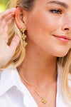 Woman wearing Berry Clover Linear Earrings - Gold, featuring classic, effortless design with three gold clover clusters and a matching pendant, embodying high-end, fun jewelry style.
