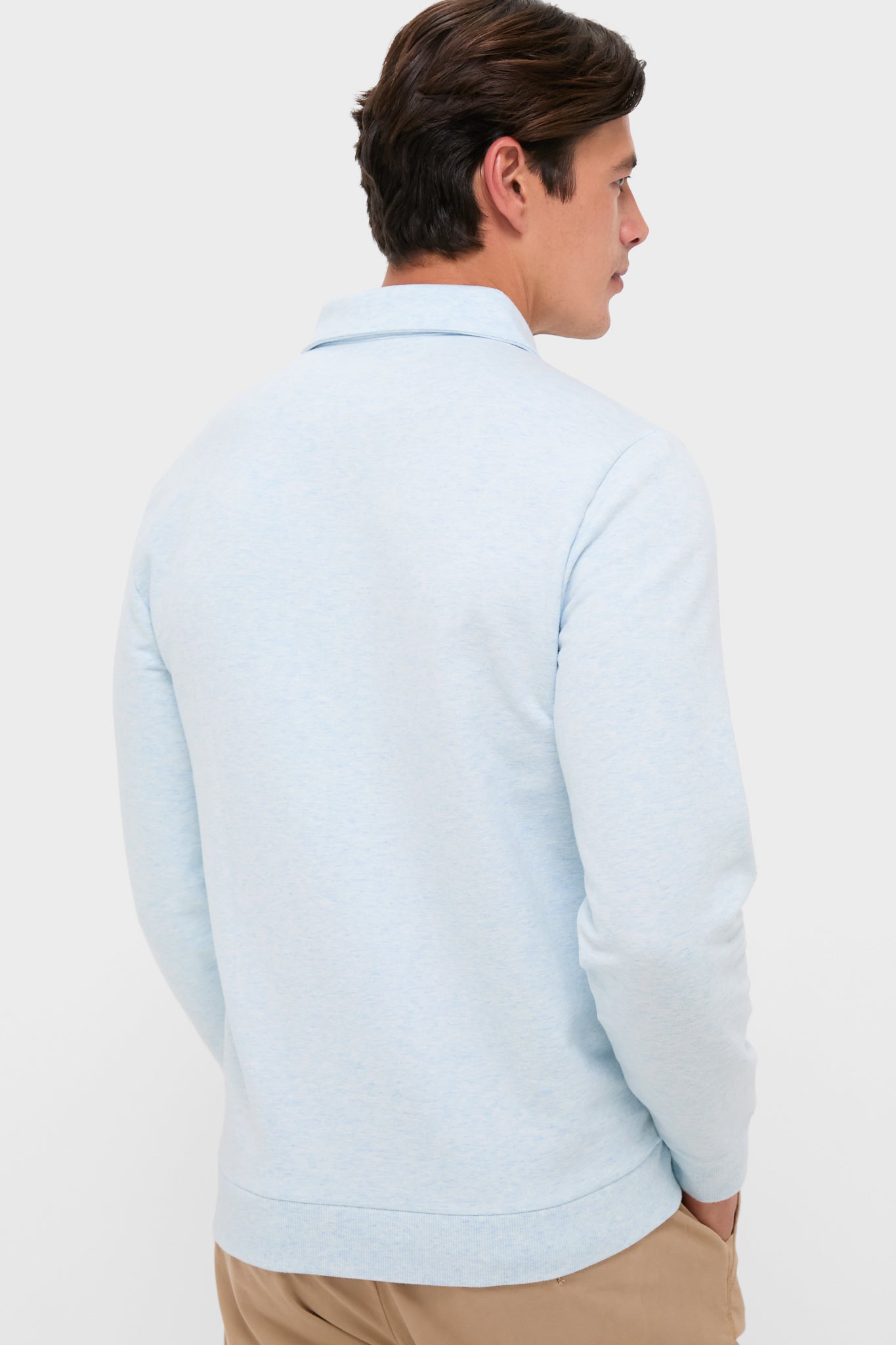 Man wearing the Heathered Ice Collared Sweatshirt, a classic and effortless long-sleeve polo-style sweater by Criquet, featuring a collar and kangaroo pouch pocket.