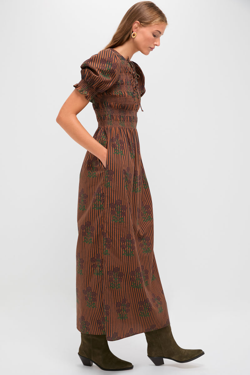 Model in a classic, effortless Multi Maribel Maxi Dress with puff sleeves and floral print, styled with olive suede boots, embodying a fun, high-end look.