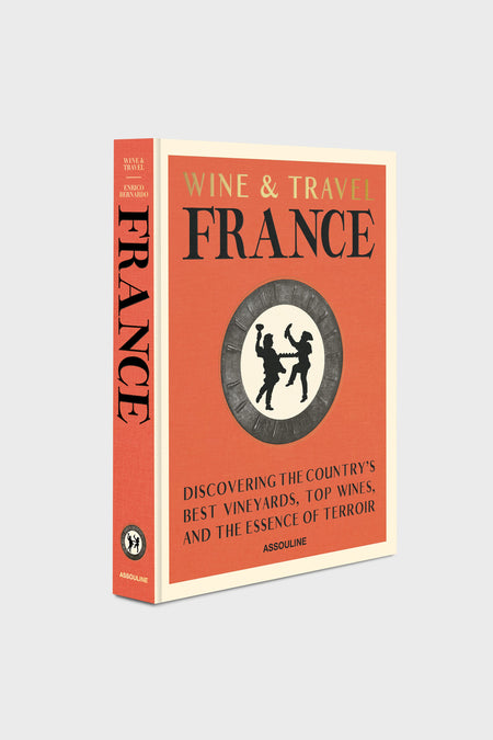 Assouline’s hardcover book "Wine & Travel France," featuring a red cover with a circular illustration and subtitle on French vineyards and terroir, is ideal for wine tourism fans and lovers of luxury travel books.