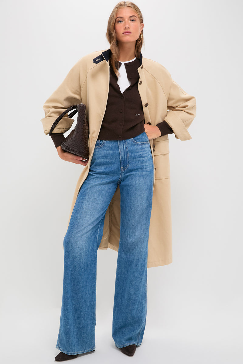 Model in a classic French Kiss Taylor High Rise Wide Leg jeans, styled effortlessly with a trench coat and woven tote, reflecting modern, high-end style.