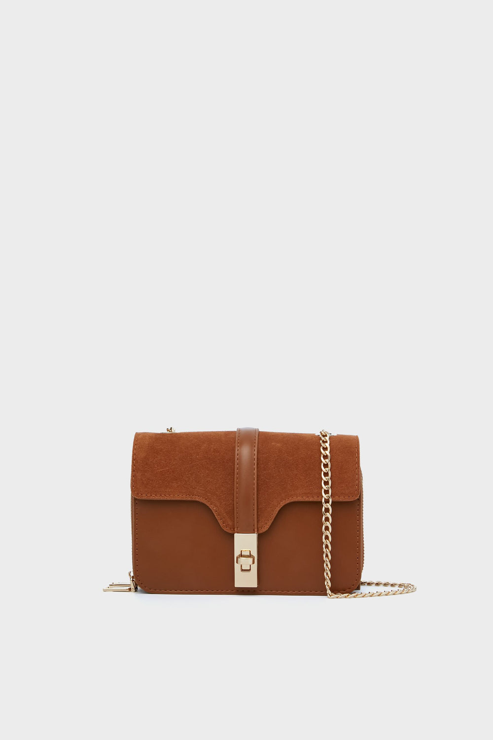 The Moda Luxe brown vegan leather and suede crossbody bag features a gold chain strap and clasp, making it a stylish fashion accessory.