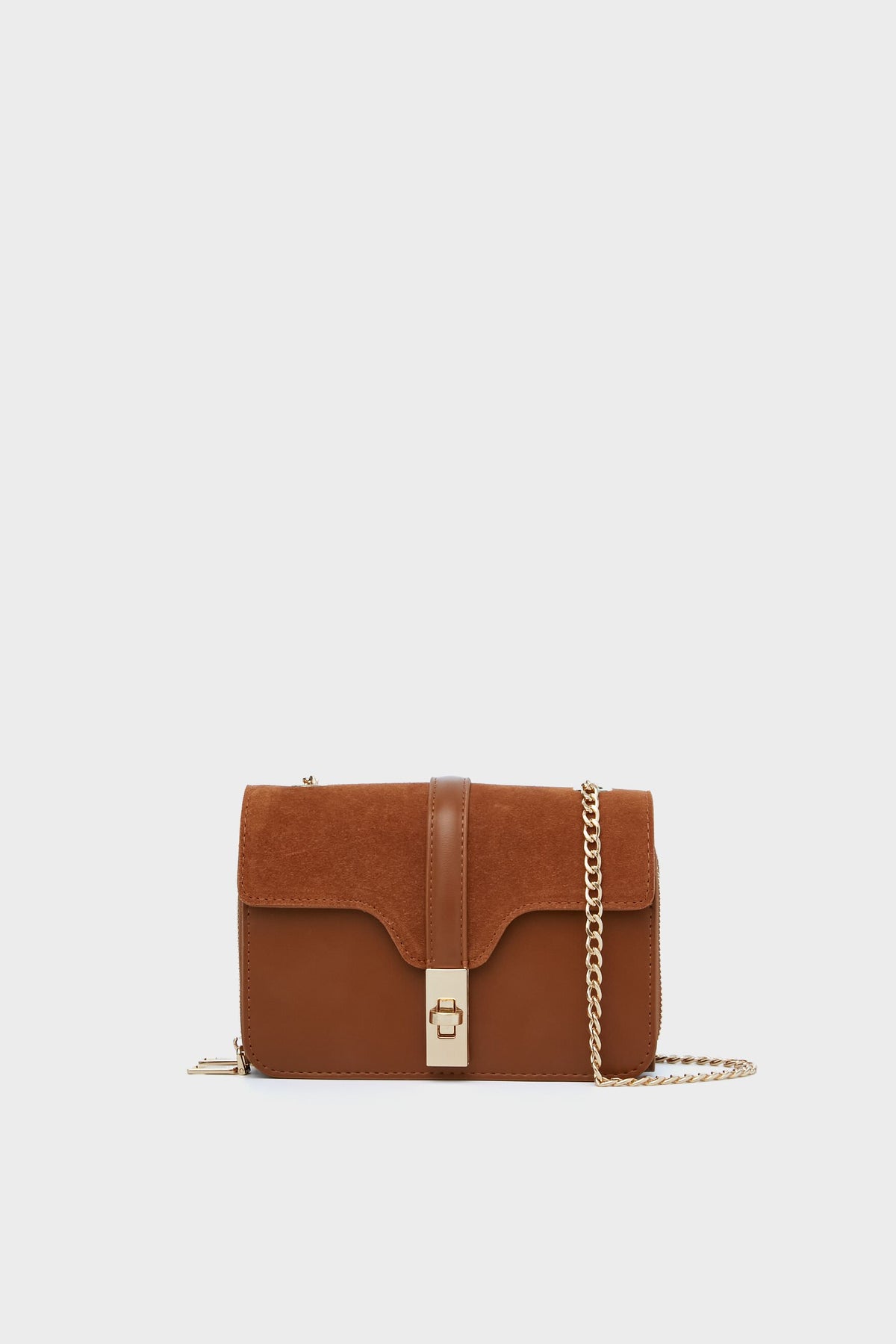 The Moda Luxe brown vegan leather and suede crossbody bag features a gold chain strap and clasp, making it a stylish fashion accessory.