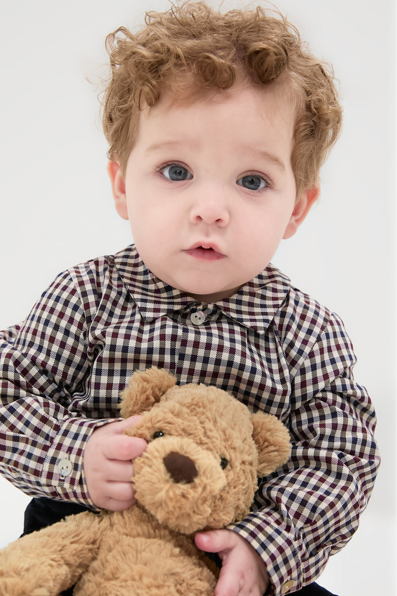 Toddler in classic Burgundy Check Arlo Baby Boy Set, effortlessly holding a teddy bear, showcasing high-end Spanish craftsmanship with a check-patterned shirt and corduroy shorts.