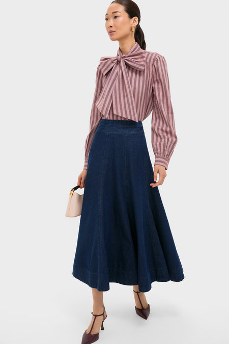 Model wearing the classic Mauve Stripe Brianna Bow Blouse with a dramatic bow, paired effortlessly with a high-end denim skirt and fun burgundy heels, showcasing an elegant, confident style.