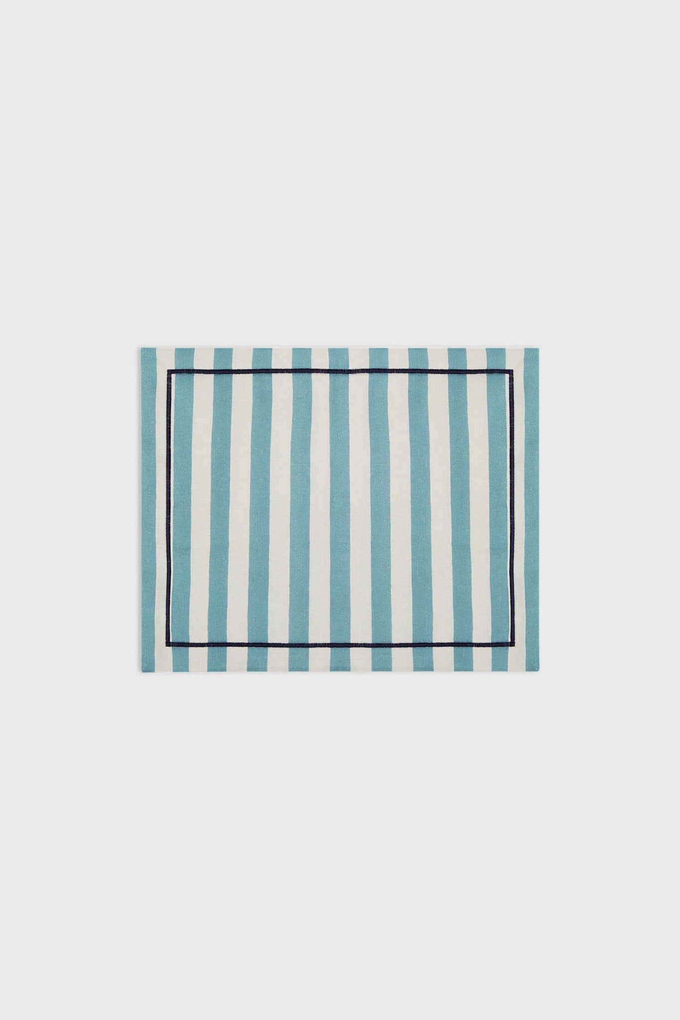 La DoubleJ rectangular linen placemat featuring blue and white vertical stripes with a slim dark border, inspired by classic Italian textile design.