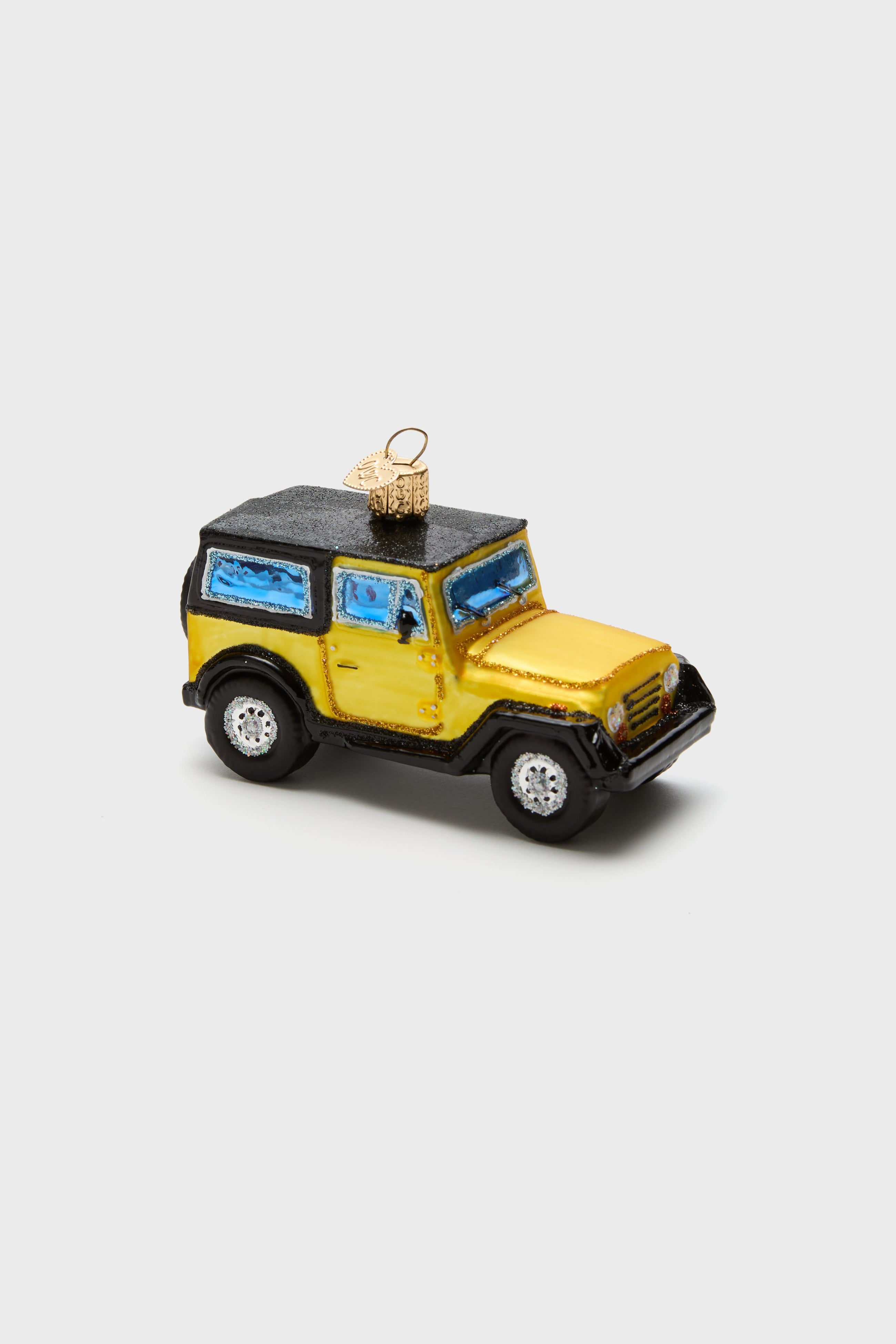 Old World Christmas hand-painted, glass-blown ornament shaped like a yellow and black SUV, with blue windows and a gold hanging loop on top.