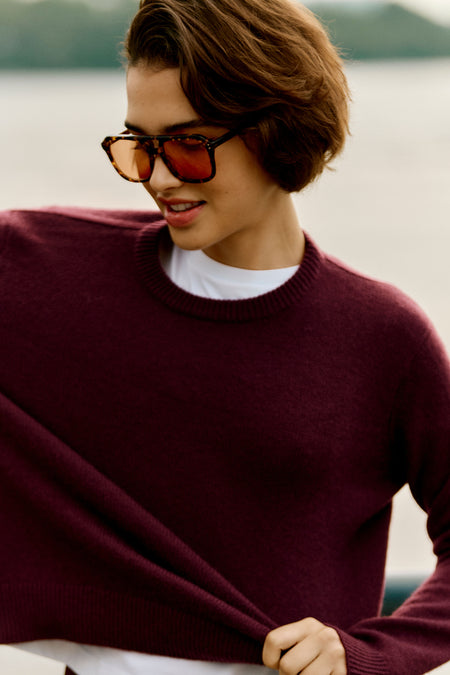 Model wearing the classic Winetasting Cashmere Bodie Boyfriend Crewneck, effortlessly chic with a relaxed fit, showcasing high-end style and fun, playful elegance.