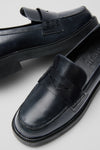 Black Dylan Loafers: Classic black leather penny loafers featuring a polished finish, rounded toe, and chunky sole for an effortless, high-end style that's fun and versatile.