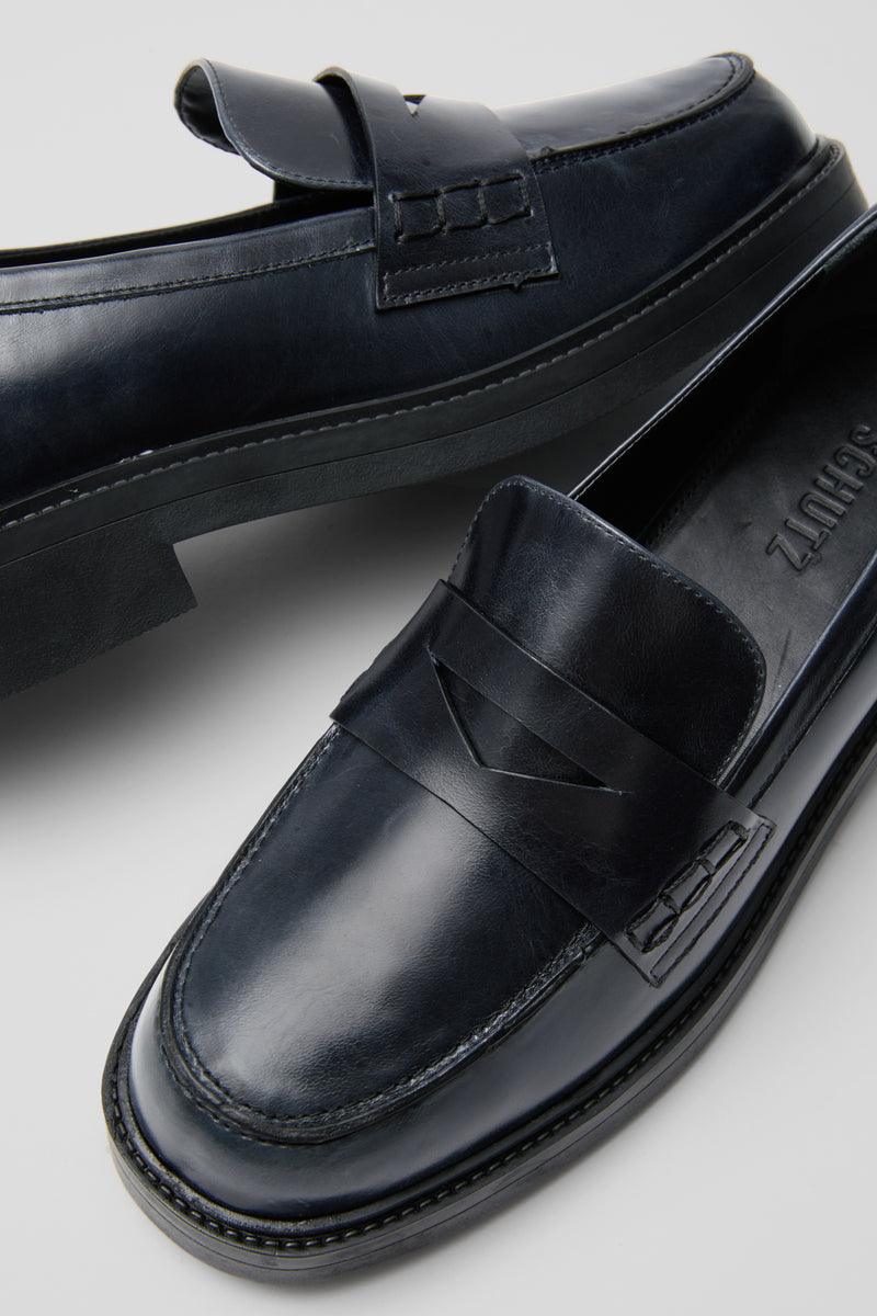 Black Dylan Loafers: Classic black leather penny loafers featuring a polished finish, rounded toe, and chunky sole for an effortless, high-end style that's fun and versatile.