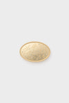 Cesoli oval-shaped gold brooch featuring a textured surface and beaded edge, inspired by a gold charm buckle.