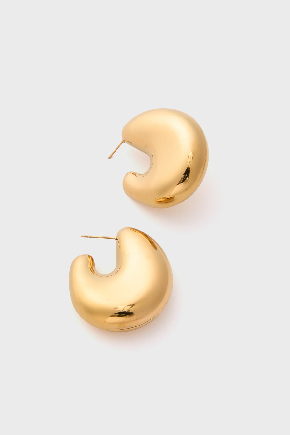 A pair of chunky, crescent-shaped Petit Moments Gold Bean Hoop Earrings shine with gold-tone elegance.