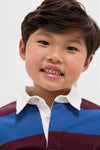 Young child wearing the Petrol Blue Stripe Tijo Long Sleeve Boy Rugby Shirt, showcasing a classic, effortless style with broad stripes and a white collar, exuding fun and high-end charm.