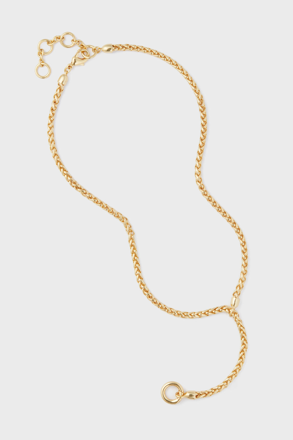 The Tuckernuck Jewelry Gold Lariat Necklace features a basket weave chain, adjustable clasp, and a circular pendant ring, all crafted from gold-plated brass.