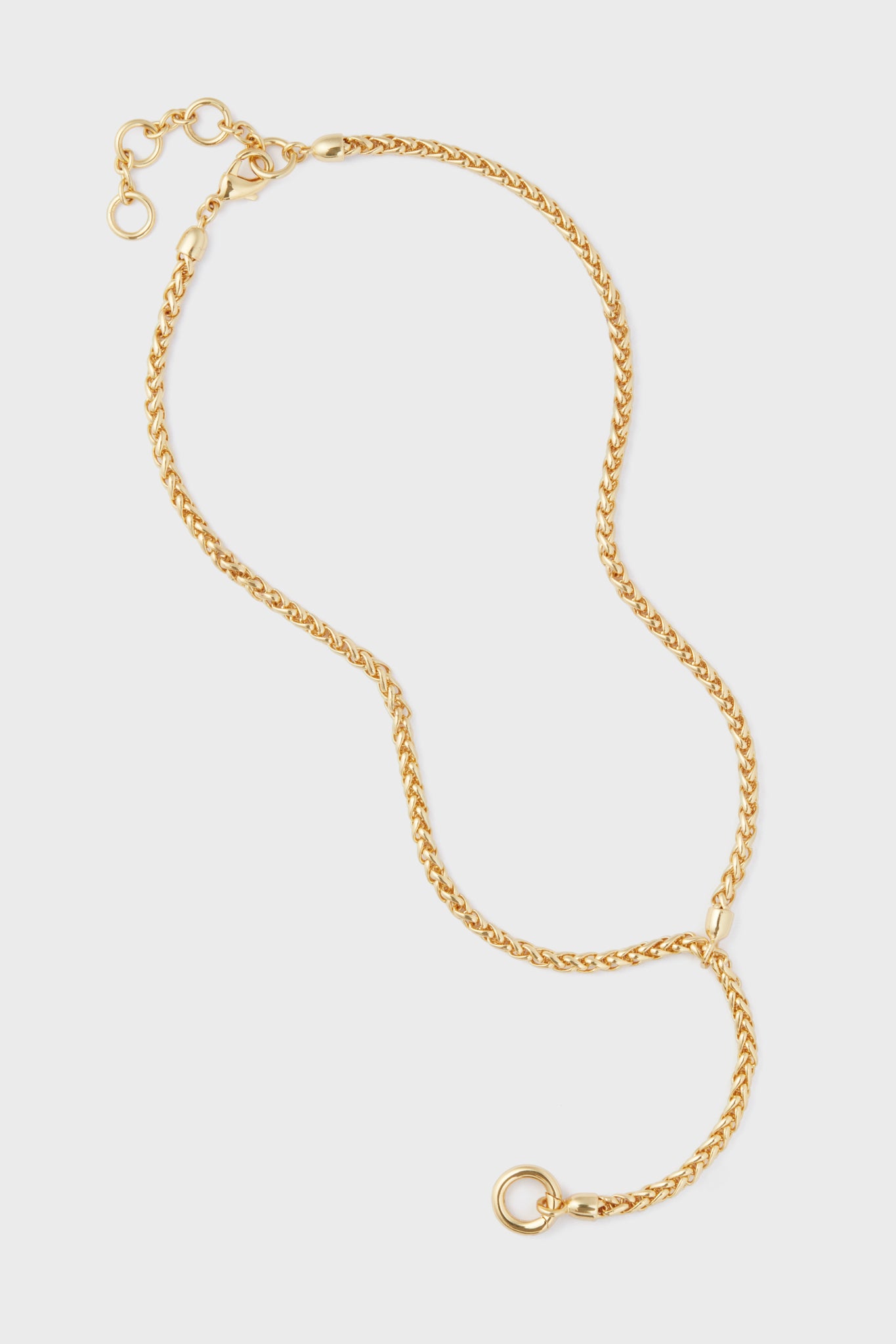 The Tuckernuck Jewelry Gold Lariat Necklace features a basket weave chain, adjustable clasp, and a circular pendant ring, all crafted from gold-plated brass.