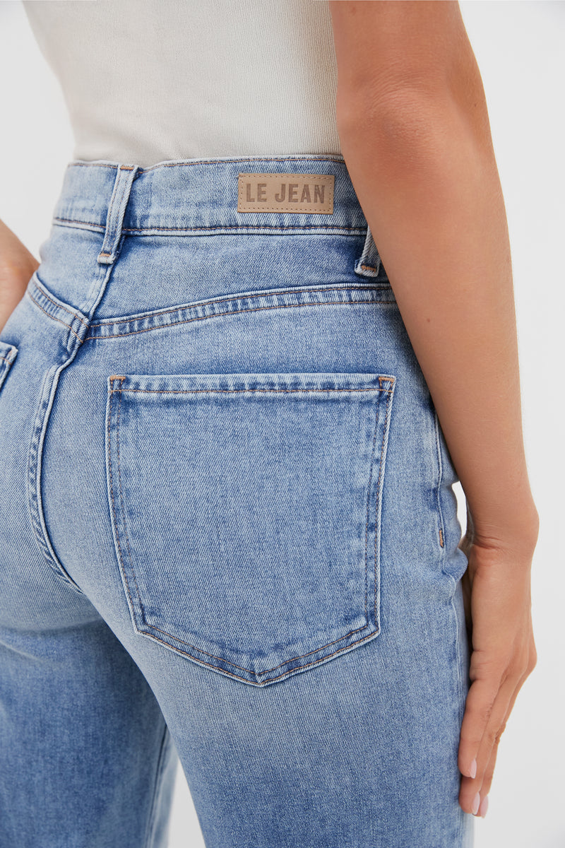 Close-up of classic, high-waisted light-blue jeans with LE JEAN label, showcasing effortless, vintage-inspired style from the Big Chill 90's Mid Rise Straight Ankle collection.