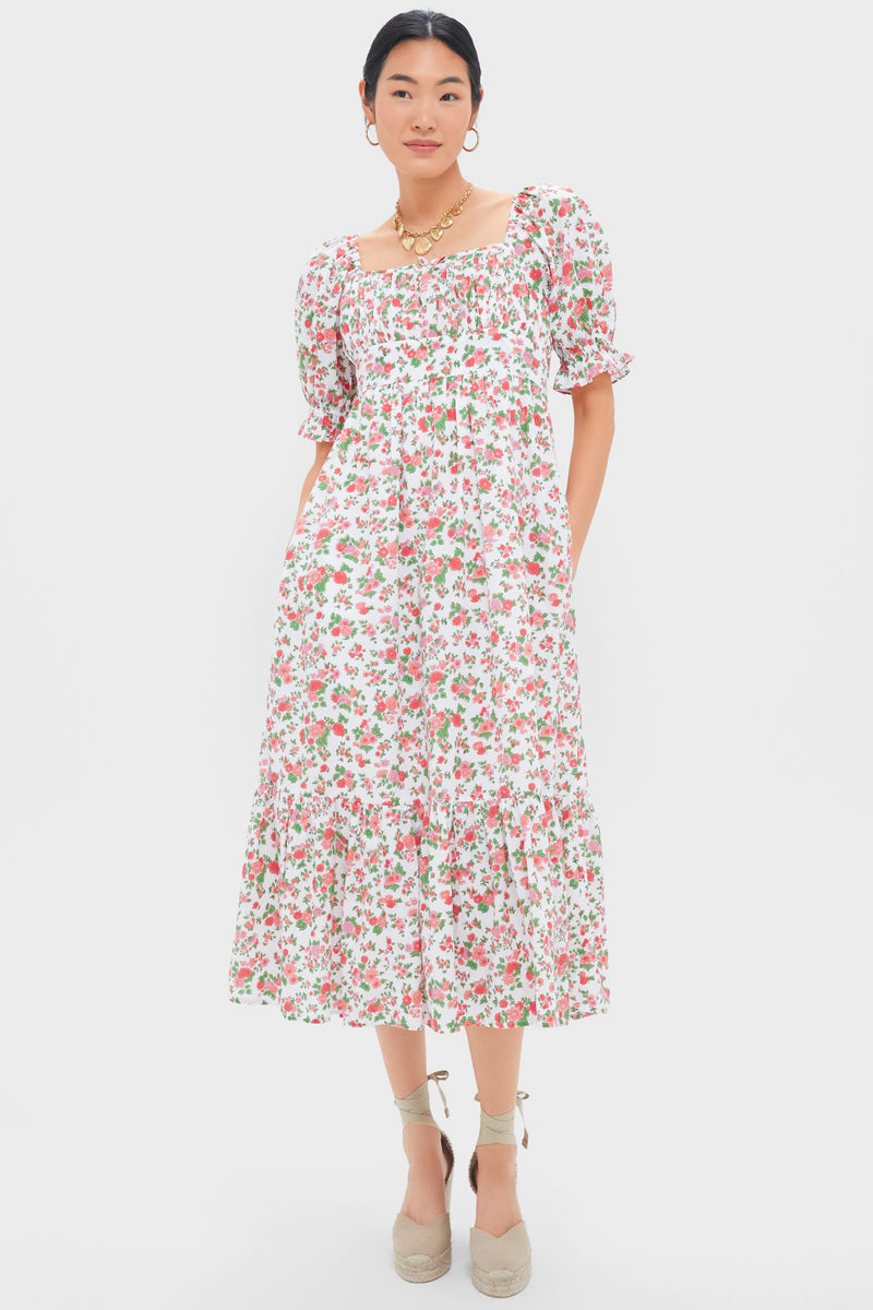 A woman wears a Pink City Prints white hand block printed floral midi dress with puff sleeves and a ruffled hem, styled with beige espadrille wedges and gold jewelry.
