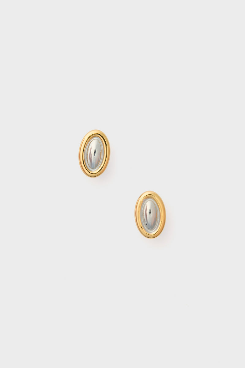 A pair of oval studs by Petit Moments featuring silver-toned centers and gold-toned borders—ideal everyday earrings.