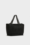 The Tuckernuck Accessories black suede tote bag features double handles and a minimalist design, ideal for carrying daily essentials or using as a stylish laptop bag. Shown against a plain light background.