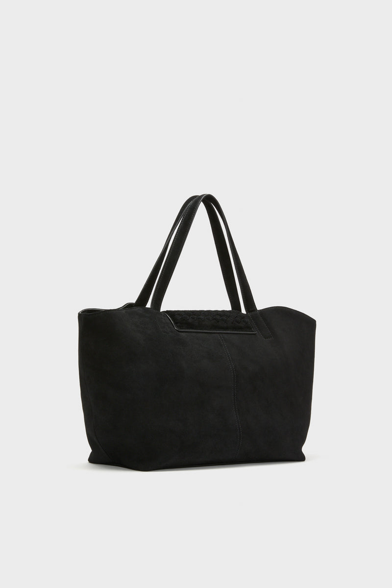 The Tuckernuck Accessories black suede tote bag features double handles and a minimalist design, ideal for carrying daily essentials or using as a stylish laptop bag. Shown against a plain light background.