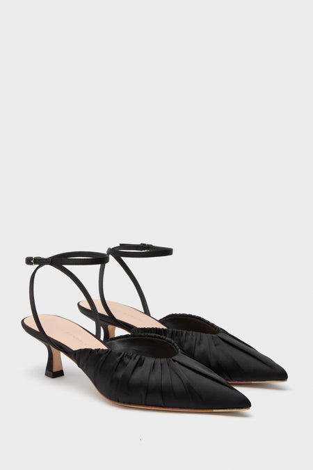 A pair of Loeffler Randall black satin slingback heels with pleated details and low kitten heels, shown on a white background.