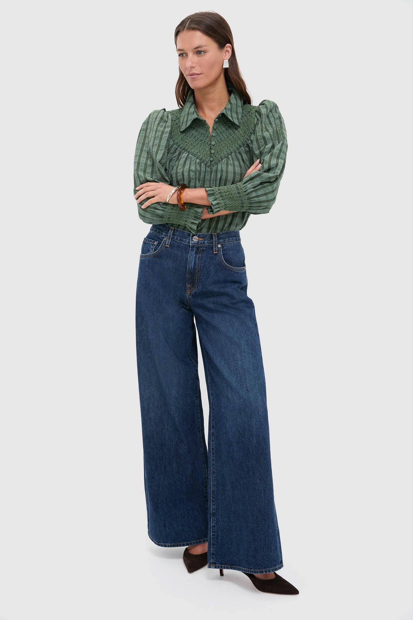 Model wearing the Green Windowpane Seersucker Vail Blouse with smocked details, paired effortlessly with wide-leg jeans and heeled pumps, epitomizing classic, high-end style.