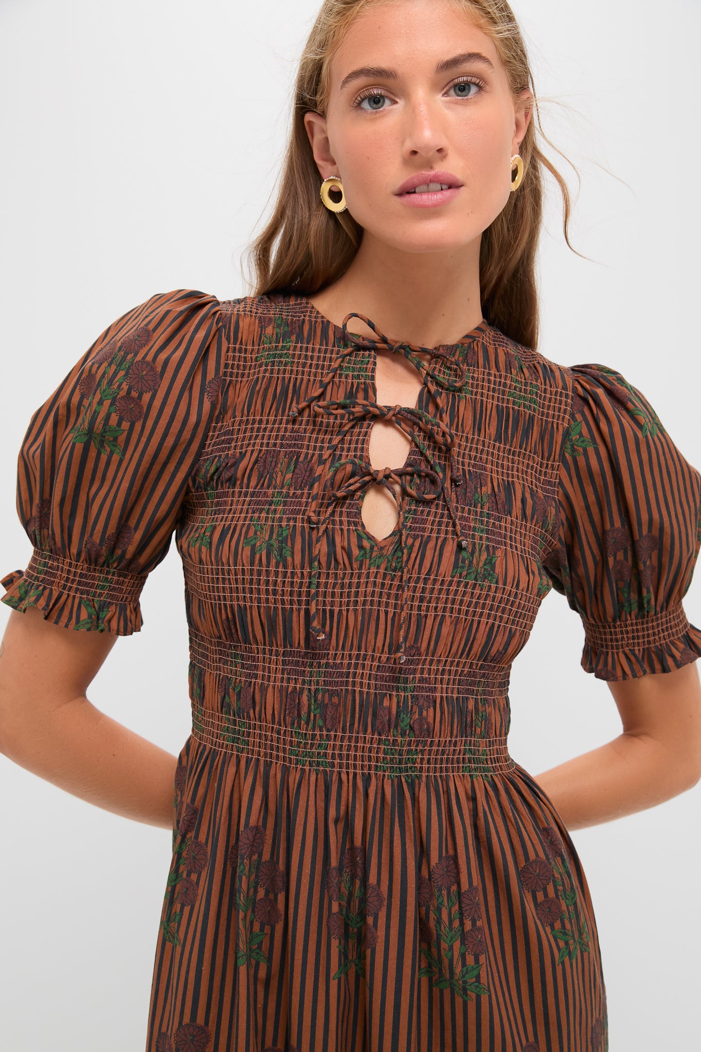 Model in the Multi Maribel Maxi Dress by Saylor, featuring classic smocked bodice, effortless puff sleeves, and fun lace-up keyhole neckline, embodying high-end style.