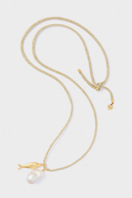 The HART Gold Lurex Cord Necklace features a gold fish charm and an eye-catching baroque pearl pendant, adding a touch of elegance to any outfit.