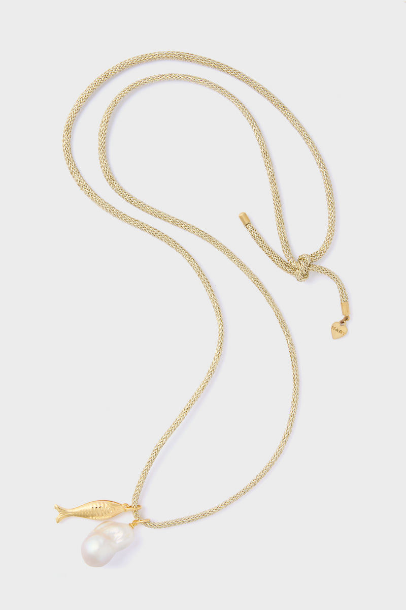 The HART Gold Lurex Cord Necklace features a gold fish charm and an eye-catching baroque pearl pendant, adding a touch of elegance to any outfit.