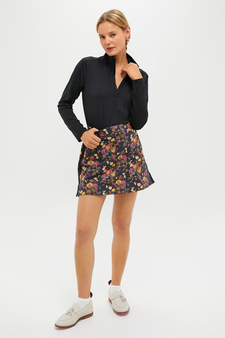 Woman wearing Baroque Floral 16 Inch Performance Stretch Woven Karrie Golf Skirt; classic A-line with compression undershorts, embodying effortless fun and high-end style.