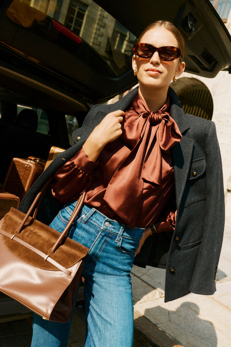 Woman holding the Hickory River Suede Shoulder Bag, showcasing its classic, effortless design with a chic suede flap and slim belt detail. Perfect for a high-end, fun look.