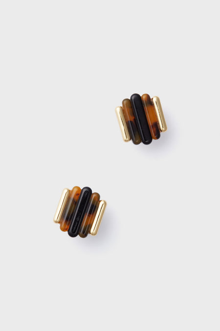 Tuckernuck Jewelry’s gold-plated tortoise earrings showcase alternating gold and brown cylindrical segments stacked vertically, creating a chic vintage-mod style.