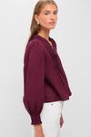 Exclusive Burgundy Anise Long Sleeve Top features classic pintuck pleating and effortless puff shoulders, paired with high-waisted trousers for a fun, high-end look.