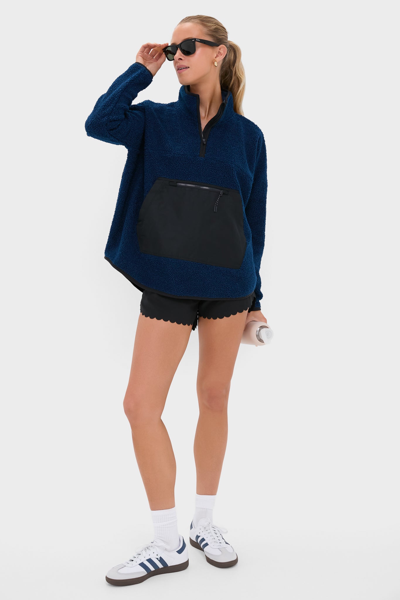 Young woman in a classic Navy Fleece Cady Quarter Zip with a sporty, effortless vibe, showcasing a sherpa-style fleece and oversized pouch pocket.
