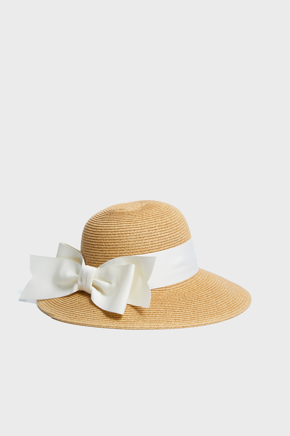 Toucan Hats presents a wide-brimmed, packable straw sunhat featuring a white ribbon and large bow—an ideal beach accessory.