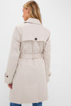Back view of a person in a classic, high-end Mist Short Greta Showerproof Jacket, showcasing effortless style with a belted waist and buttoned storm flap.