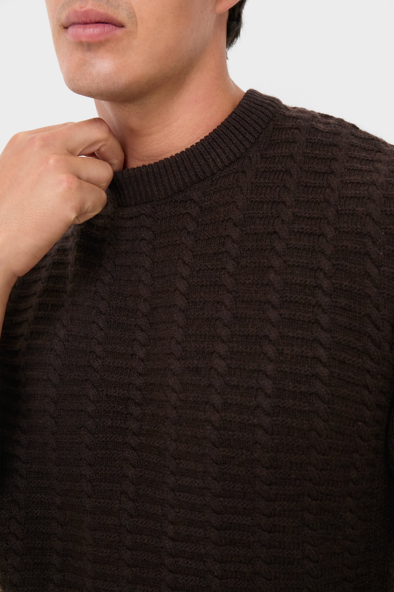 Person wearing a classic Dark Oak Cleveland Crew Neck Sweater with a cable-knit pattern, showcasing an effortless, high-end style perfect for a fun, confident wardrobe.