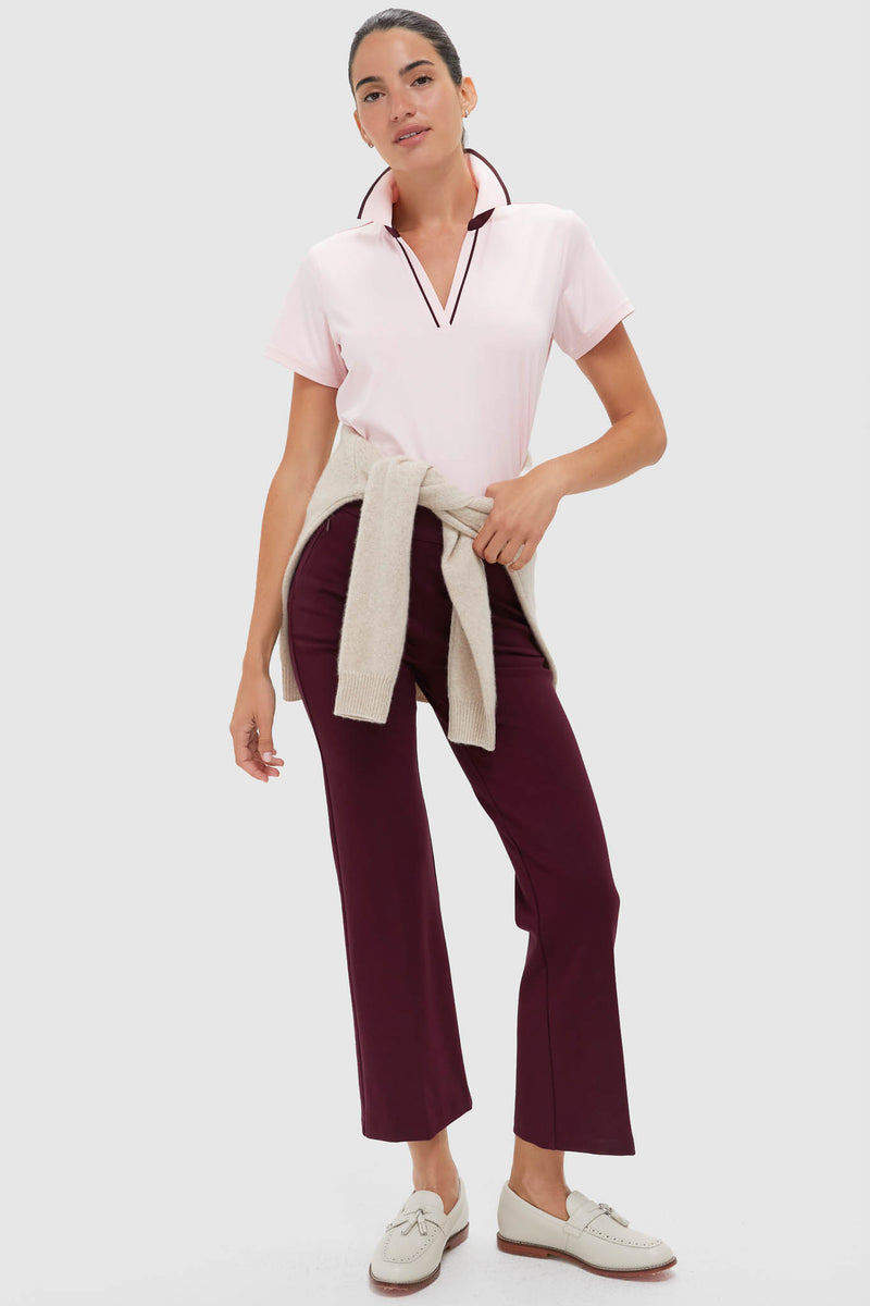 Woman models the Pink Short Sleeve Performance Jersey Caroline Polo, a classic, effortless top with a V-neck, perfect for high-end, fun, everyday wear.