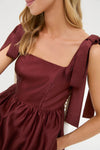 Oxblood Dupioni Bow Esme Dress features a classic square-neckline with tied bows on wide straps, offering an effortless, high-end look for fun, elegant occasions.