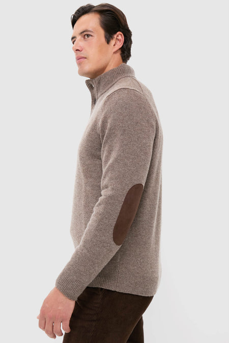 Male model wearing the Dark Stone Essential Patch Half Zip Knitted Jumper, showcasing its classic, effortless design with suede elbow patches and a high-end finish.