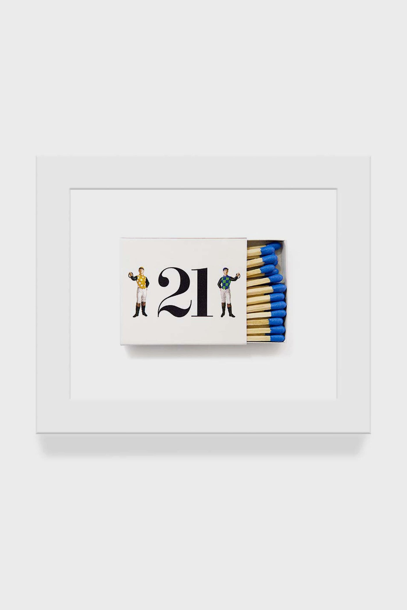The Matchbook Diaries by Charles Ryan Clarke print features a white frame, an open matchbox with blue-tipped matches, the number 21, and illustrations of two people, all captured in macro photography style.