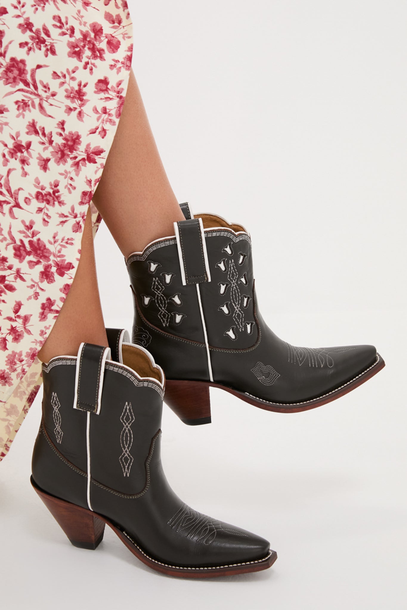 Chocolate and White Low Bright Boots, classic black leather cowboy boots with white piping, effortless style, and fun decorative stitching, paired with a floral dress for a high-end look.