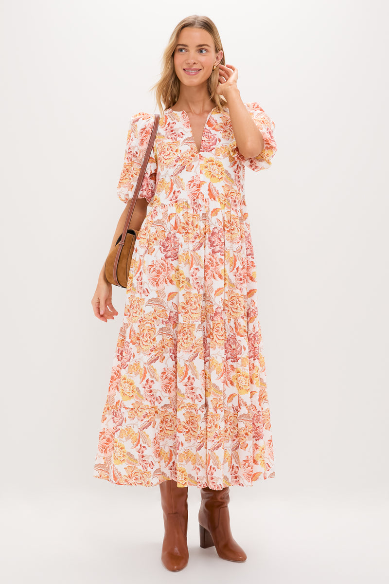 Woman in the Saffron Floral Cisco Maxi Dress, with classic puff sleeves and flowy silhouette, styled with a brown leather bag and boots, exuding effortless, high-end charm.