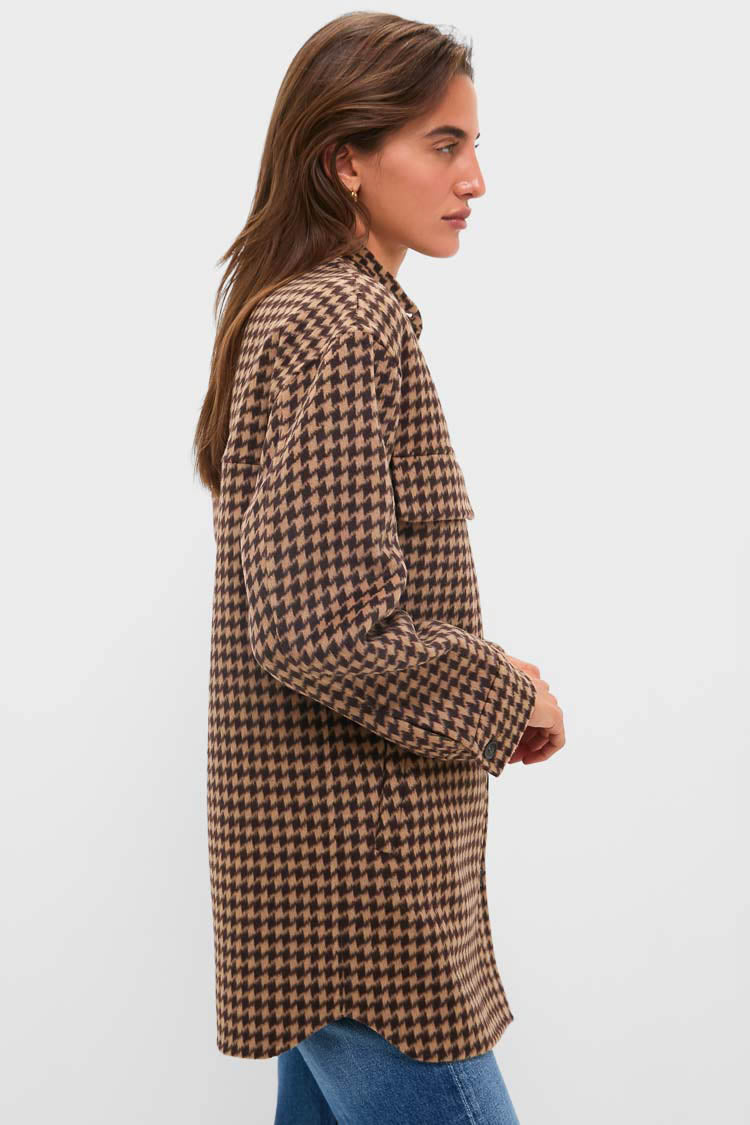 Woman in classic Noir and Noisette Florian Coat, a houndstooth shacket. Effortless and high-end, styled over blue jeans with gold hoops.