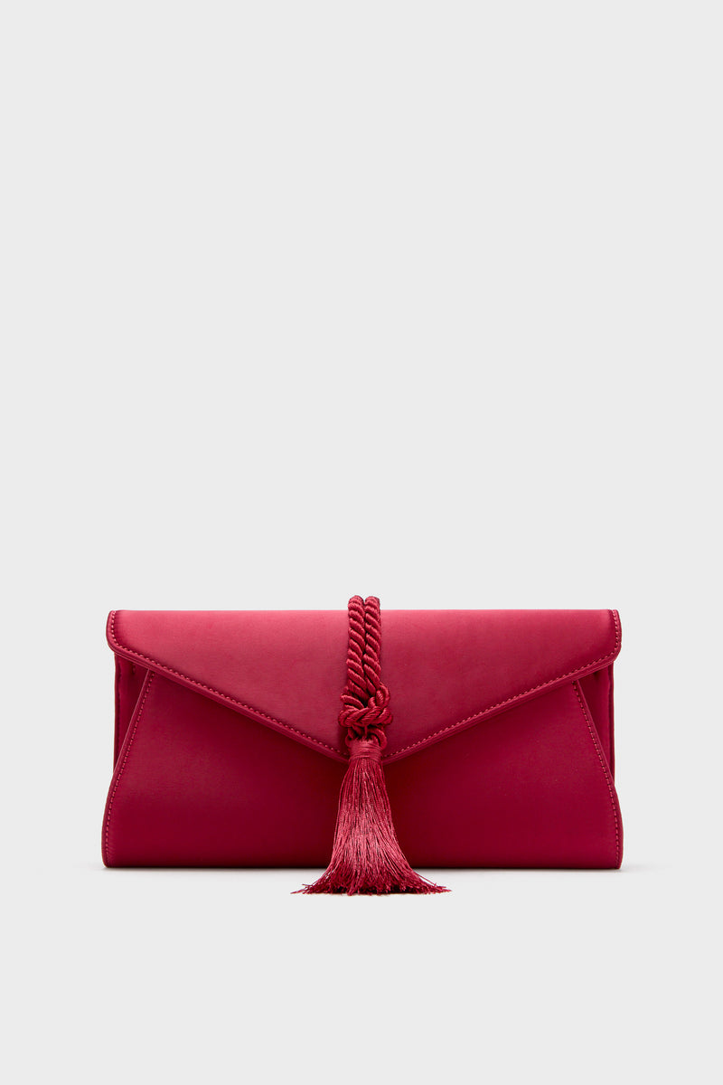 The Tuckernuck Accessories red evening clutch features a braided cord and tassel detail on the front, making it a chic party purse for stylish events.