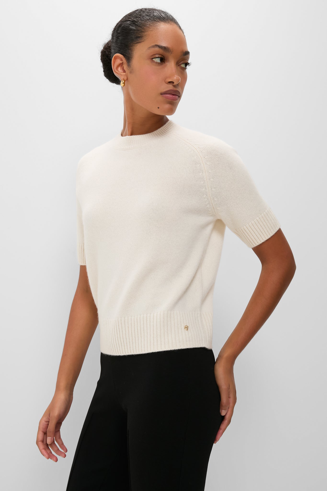 Woman wearing the classic Ivory Jackson Sweater, a high-end, effortless cashmere knit with a boxy silhouette, paired with black trousers, exuding fun and sophistication.