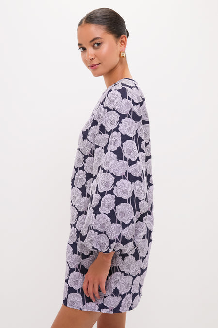 Young woman in a classic, high-end Lilac & Navy Floral Jacquard Janie Mini Dress, showcasing its effortless and fun design with long sleeves and a chic poppy print.