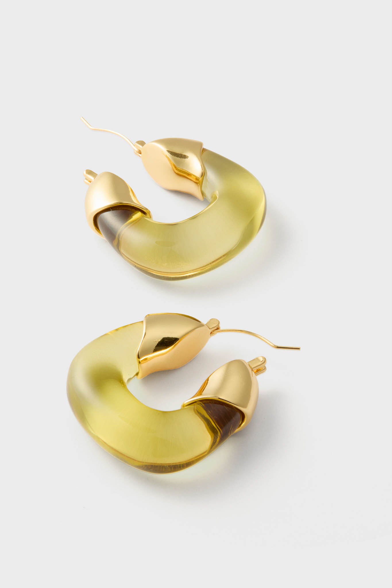 Apple Organic Hoops: Classic crescent-shaped resin earrings with gold-tone accents, offering an effortless and high-end touch for fun, sophisticated styling.