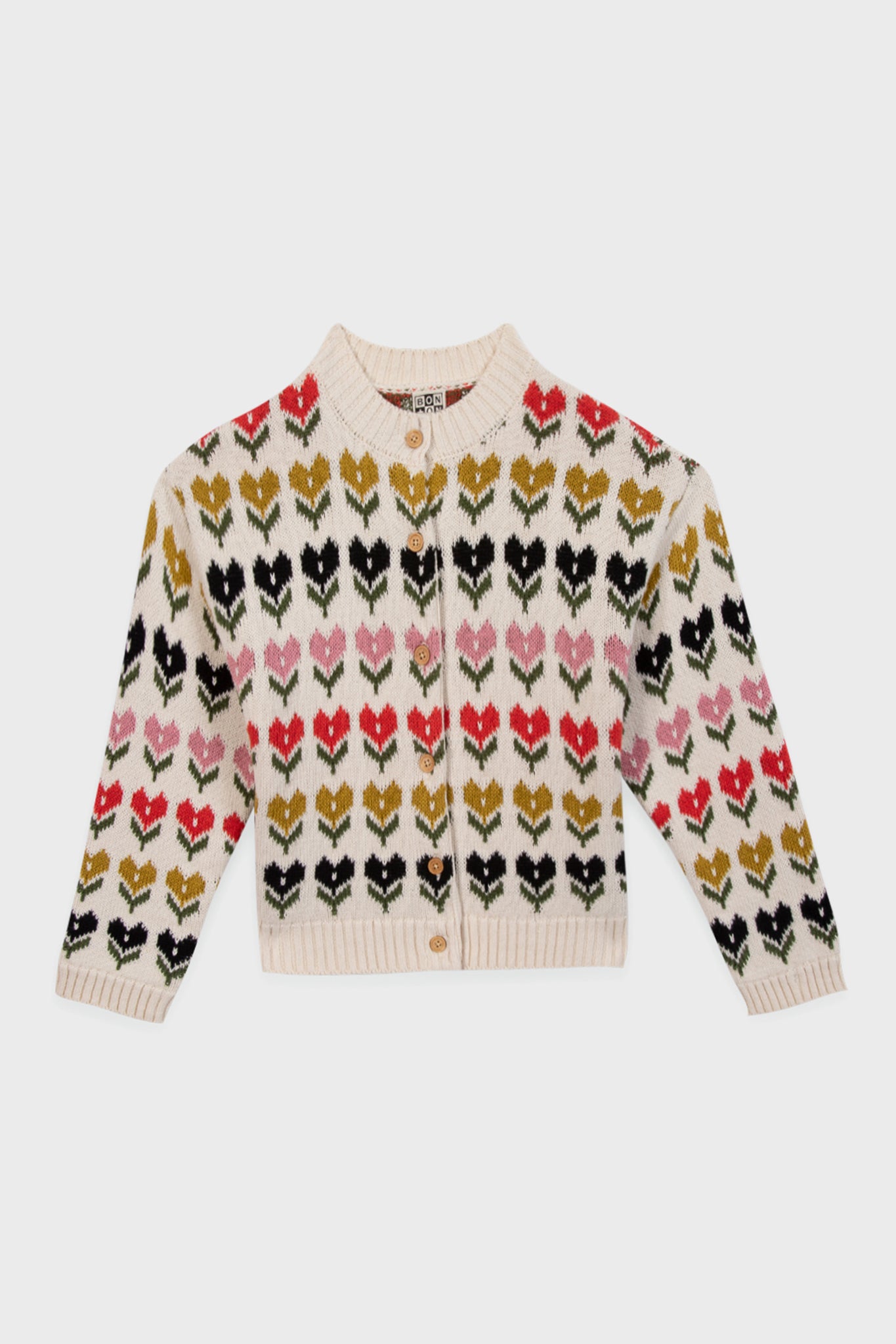 This cream Bonton cardigan features vintage-inspired hearts and chevrons in black, red, and olive green, with a round neck and front buttons—a charming piece for fans of French children's clothing.